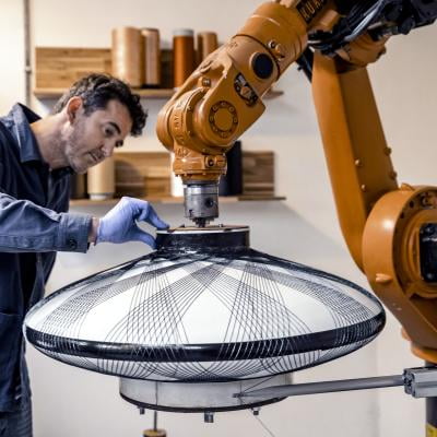 Soren Blomaard inspecteert een lampenkap die wordt geweven door een robot.