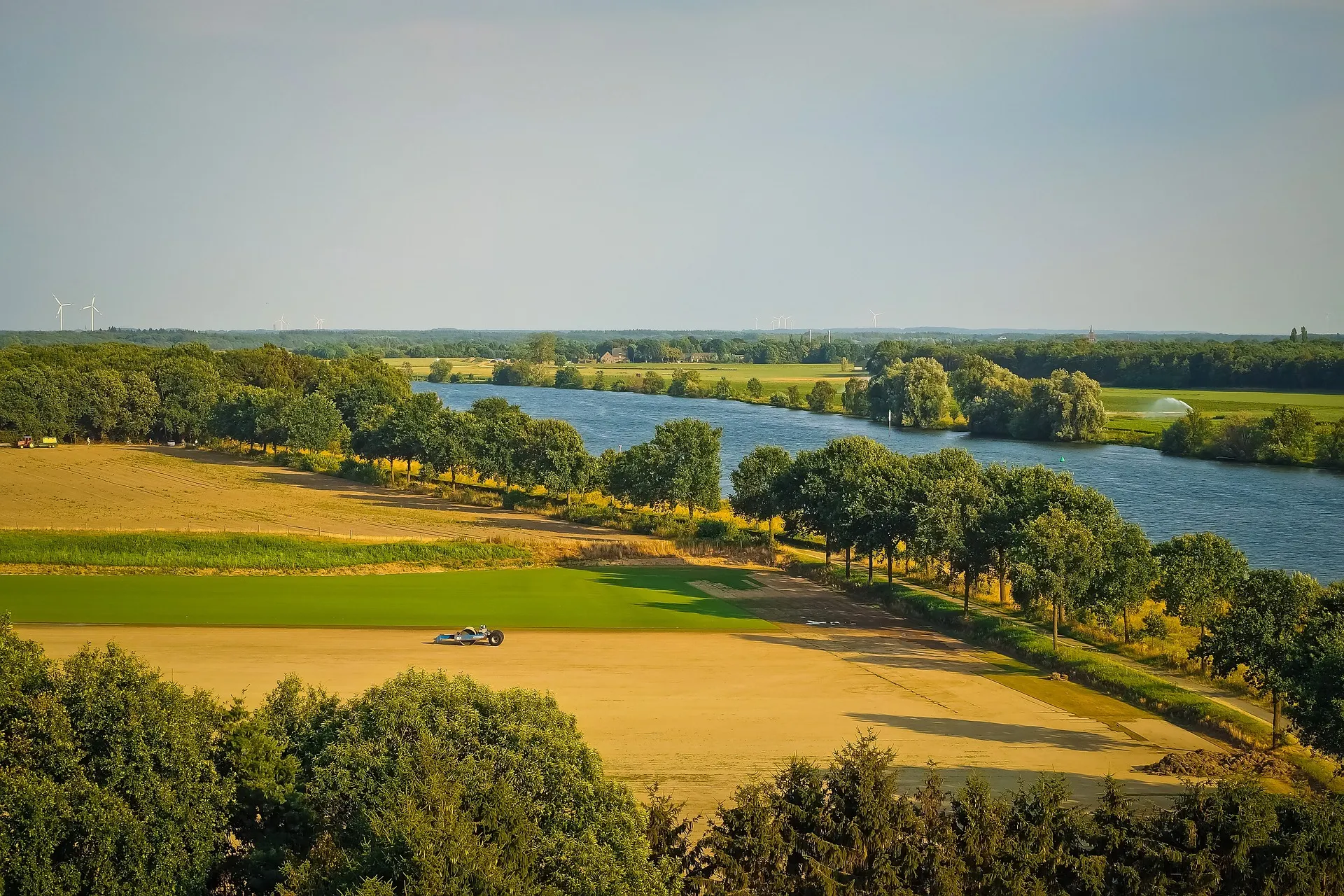 Bovenaanzicht van landbouwgrond met aan de rechterkant een rivier