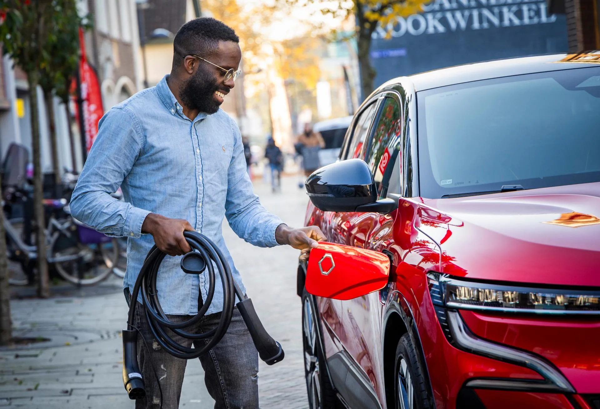 Een man laadt zijn elektrische auto op.