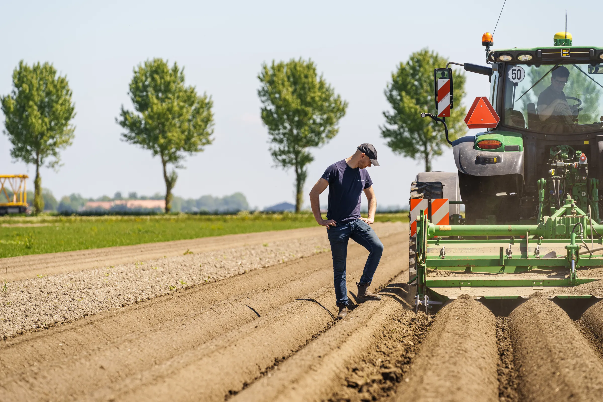 Man kijkt naar akkerbodem naar trekker