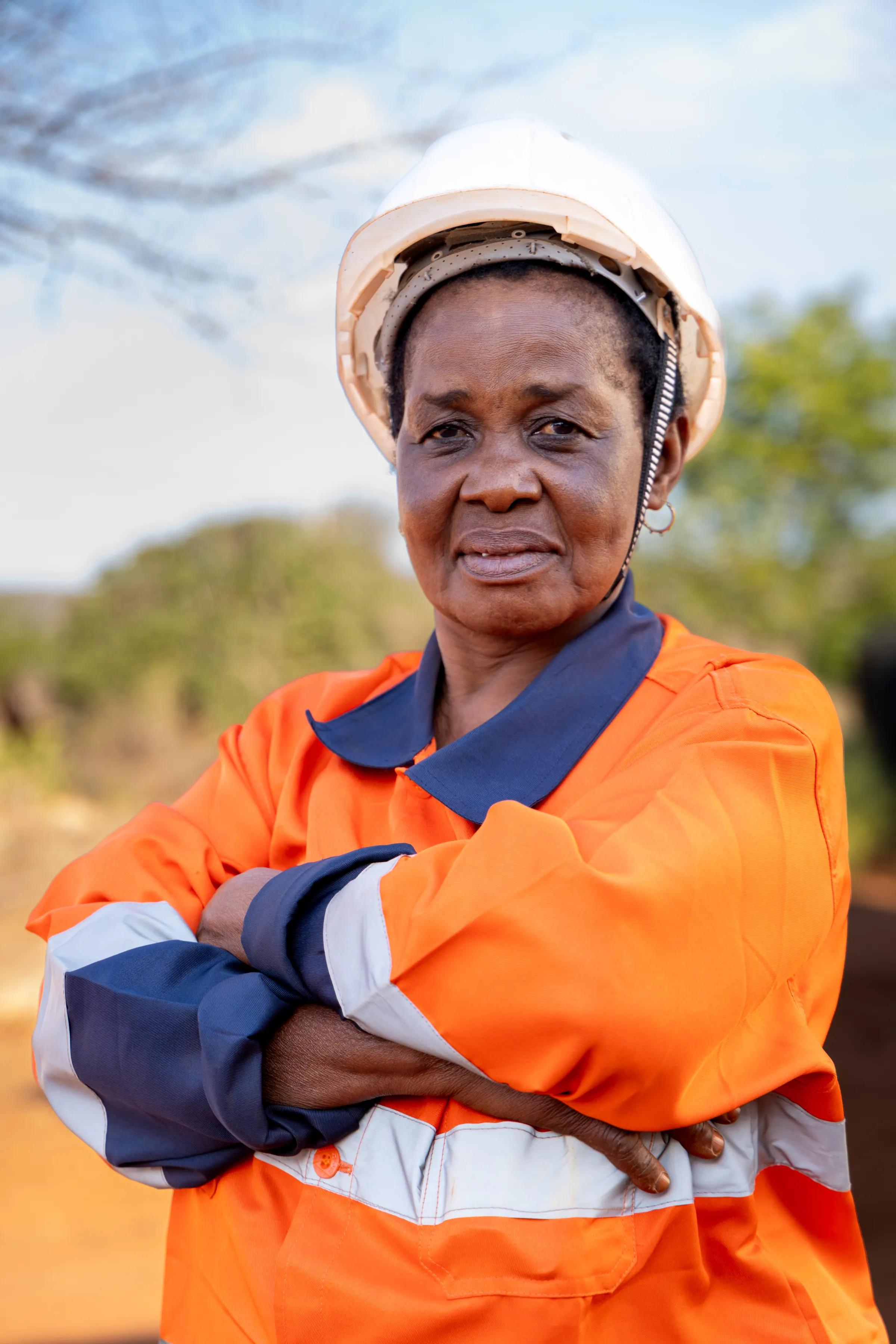Vrouwelijke mijnwerker in oranje werkkleding in Tanga, Tanzania.