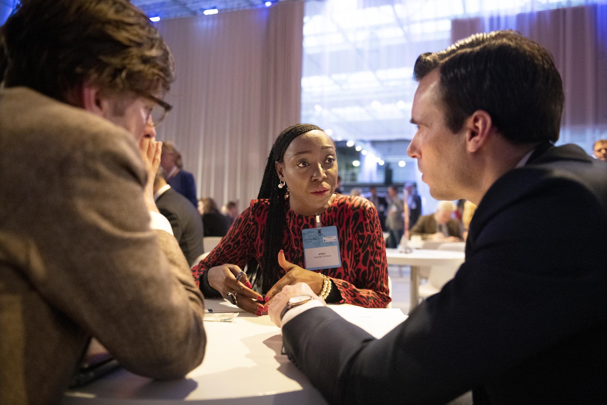 Drie personen in gesprek tijdens een netwerkevent
