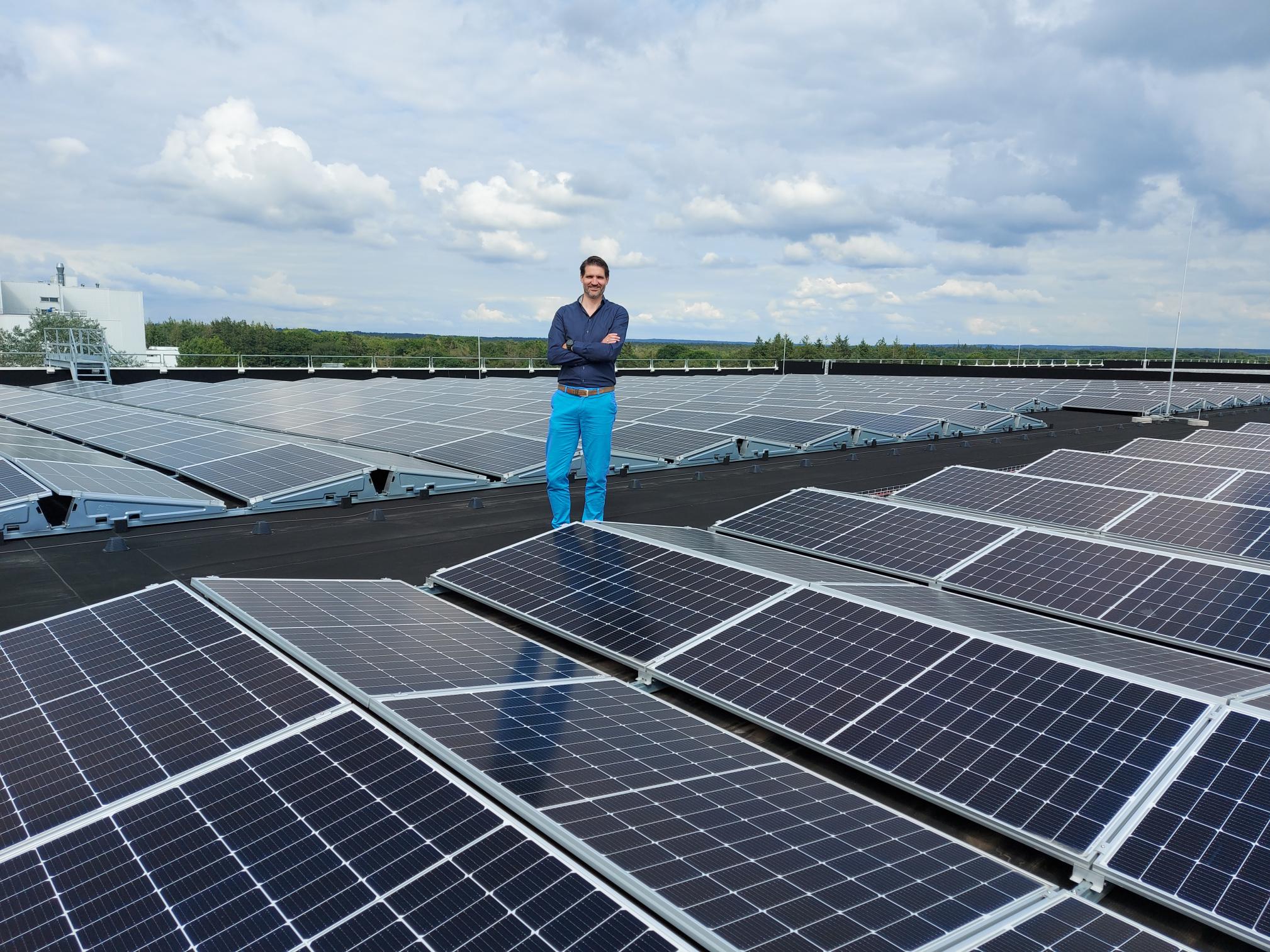 Man staat tussen duizenden zonnepanelen