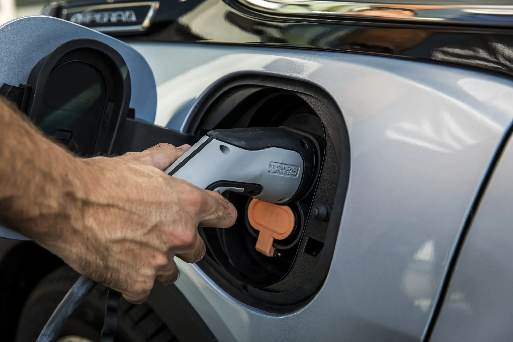 Iemand laadt een auto elektrisch op 
