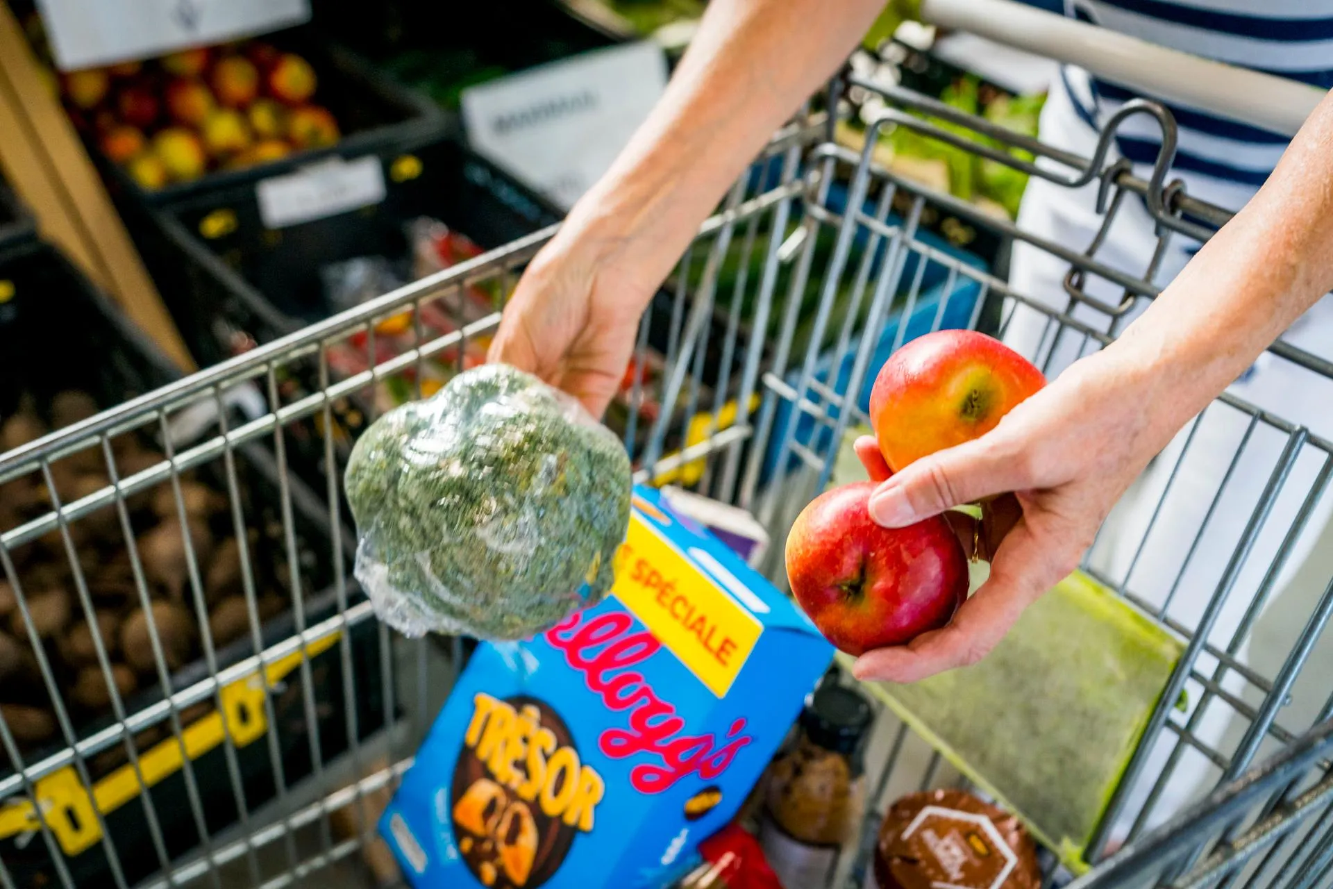 Groente, fruit en cornflakes worden in een winkelkar gelegd