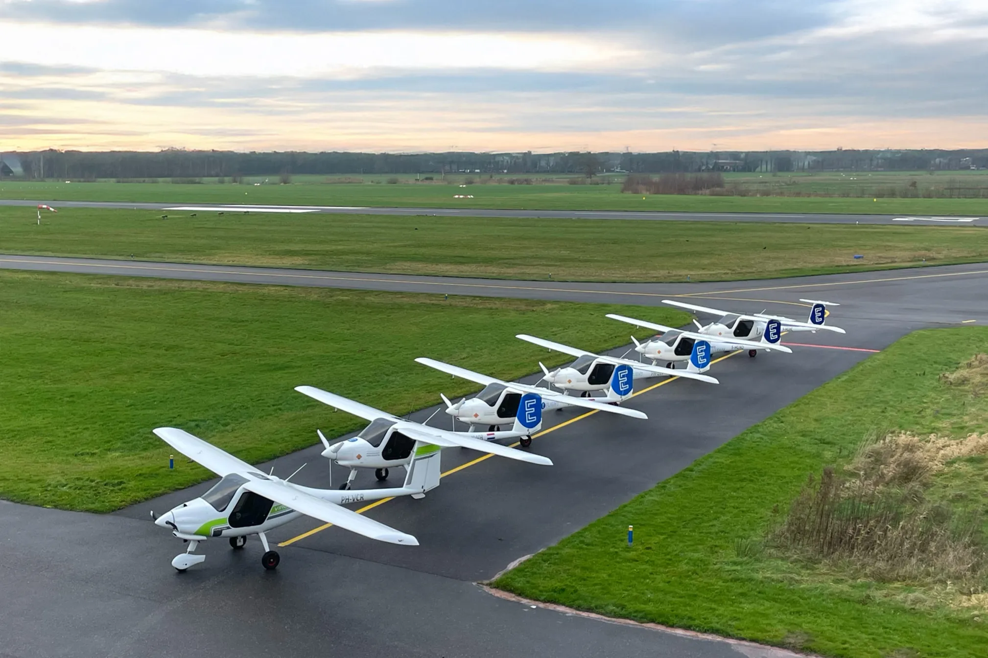 6 E Flight vliegtuigen op een rij op vliegveldje