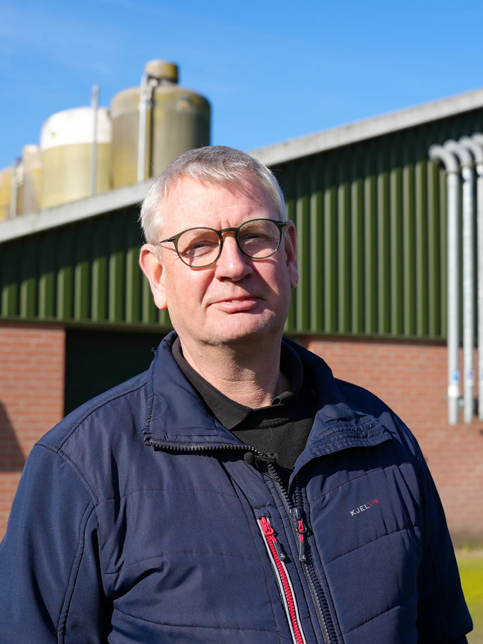 Portret van landbouwer Bauke van Dijk voor een schuur
