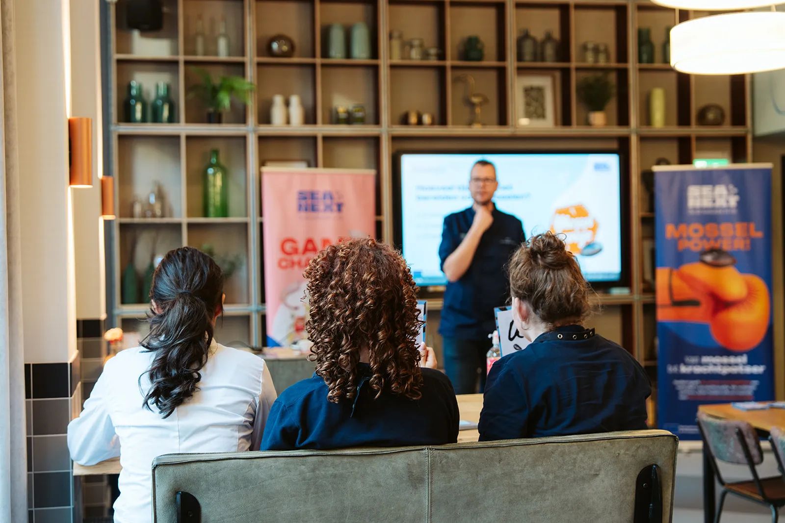 Mbo-leerlingen luisteren naar een chef-kok tijdens een kookworkshop.
